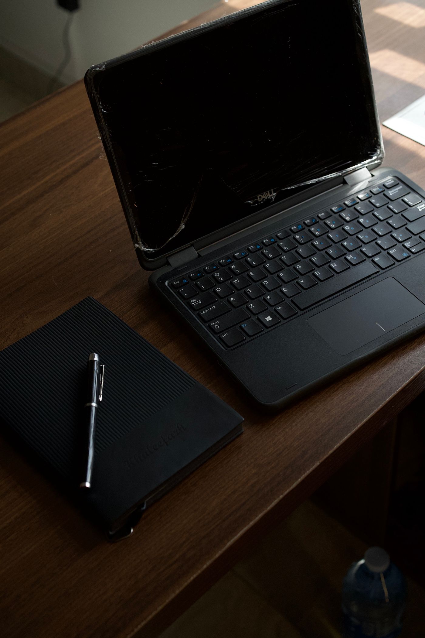 A dim office desk with a closed laptop